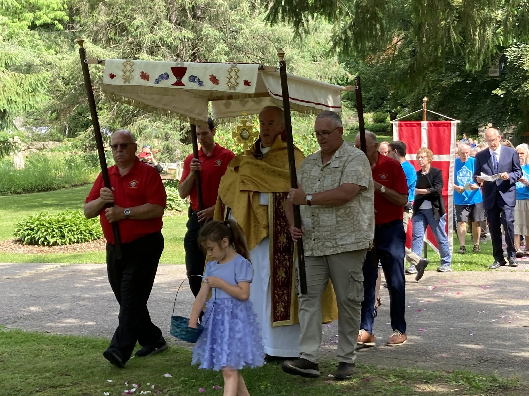 Eucharistic procession moving through the Glen beneath a ceremonial canopy