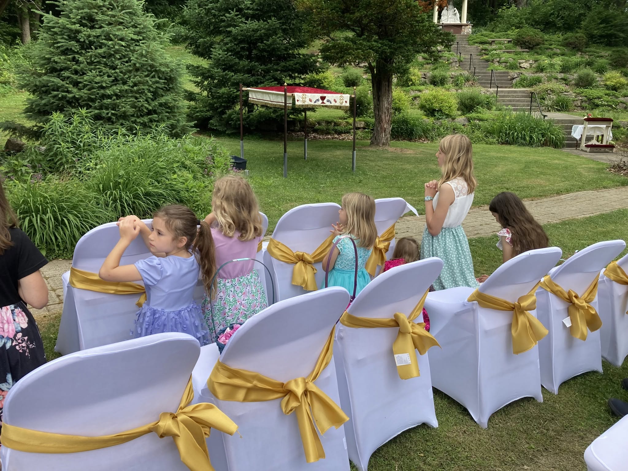 Families gathered before an outdoor altar on the Glen grounds